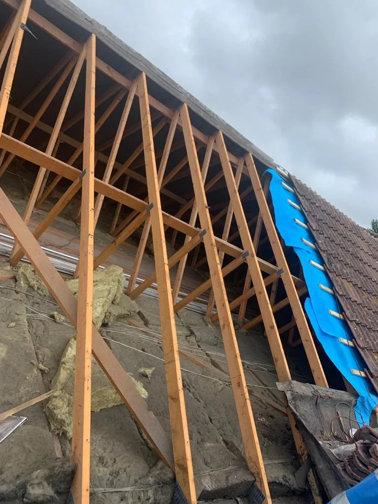 New rafters and insulation inside a roof being rebuilt