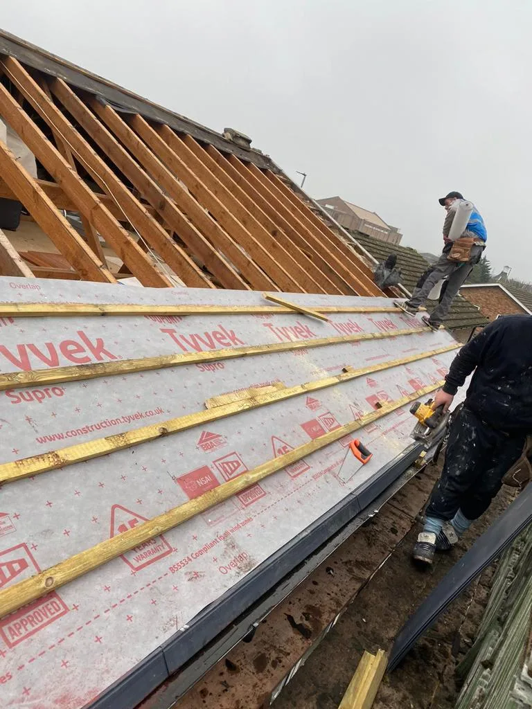 New rafters and membrane going on a roof, with the team working along the eaves
