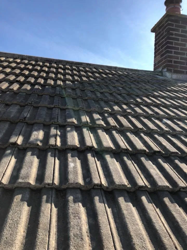 Concrete tiles running up to a brick chimney in sunlight